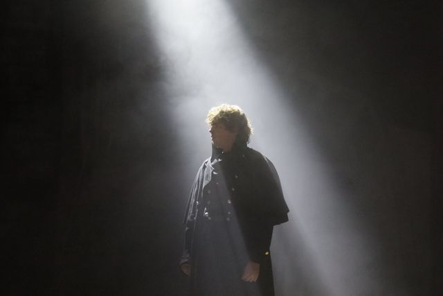 Javert alone in a shaft of light cutting through haze